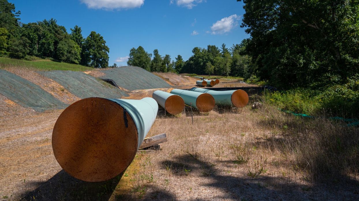 Sections of steel pipe of the Mountain Valley Pipeline lie in the sun on wooden blocks