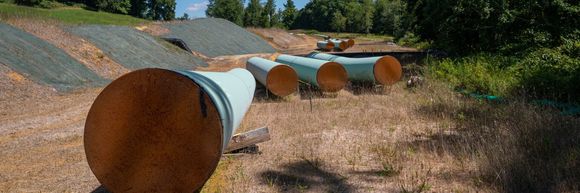 Sections of steel pipe of the Mountain Valley Pipeline lie in the sun on wooden blocks