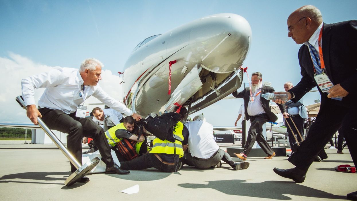 Security attempts to remove climate protesters blocking private jets at Geneva Airport