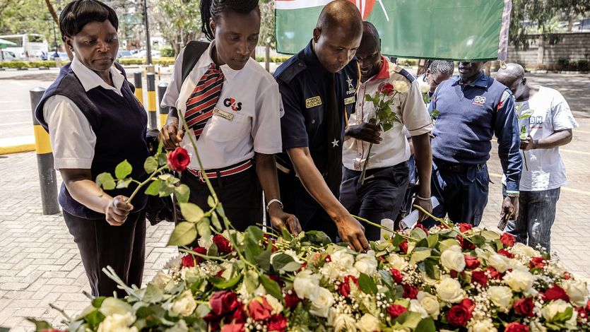 Security officers lay flowers on a memorial to terror victims in Kenya.