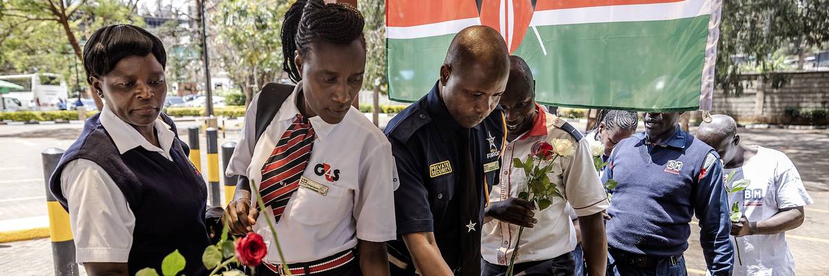 Security officers lay flowers on a memorial to terror victims in Kenya.