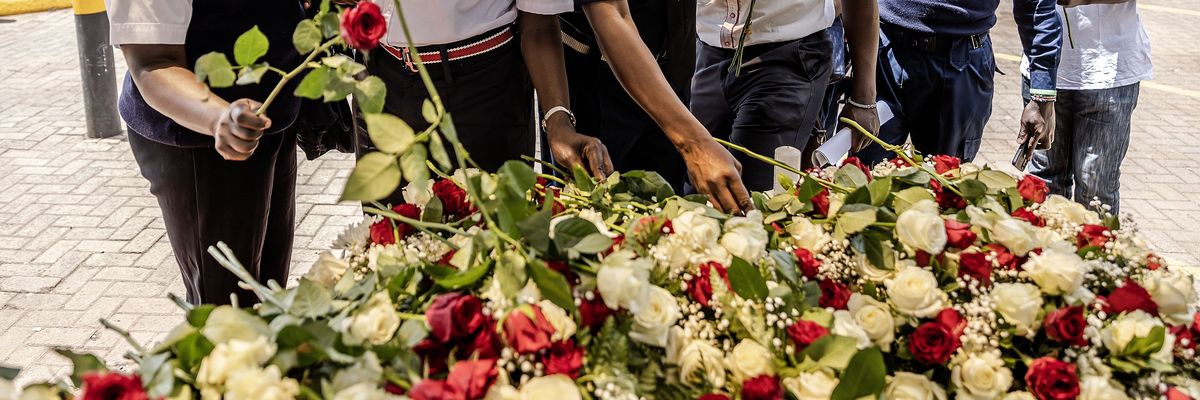Security officers lay flowers on a memorial to terror victims in Kenya.