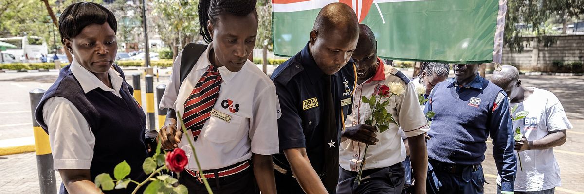 Security officers lay flowers on a memorial to terror victims in Kenya.