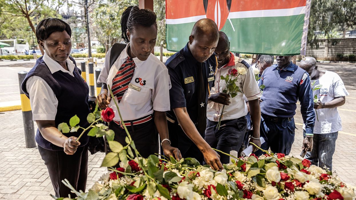 Security officers lay flowers on a memorial to terror victims in Kenya.