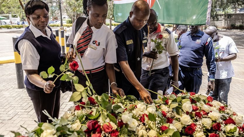 Security officers lay flowers on a memorial to terror victims in Kenya.