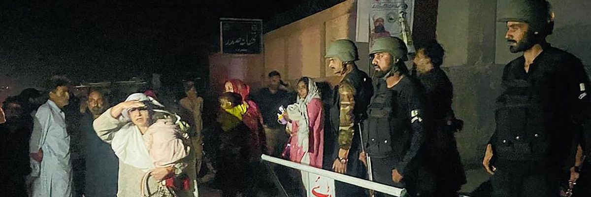 Security personnel cordon off a street as residents evacuate homes near the site of an Indian missile strike