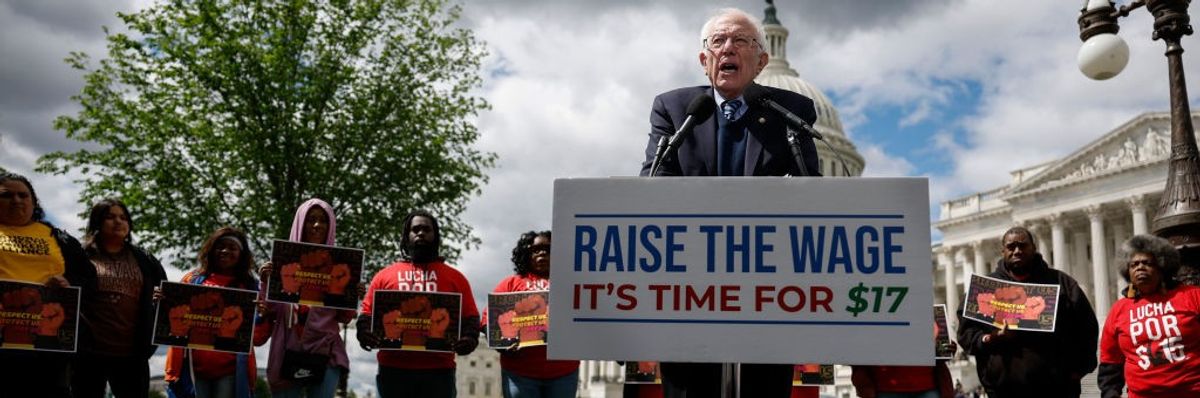 Sen. Bernie Sanders stands behind a podium that reads, "Raise the Wage: It's Time for $17."
