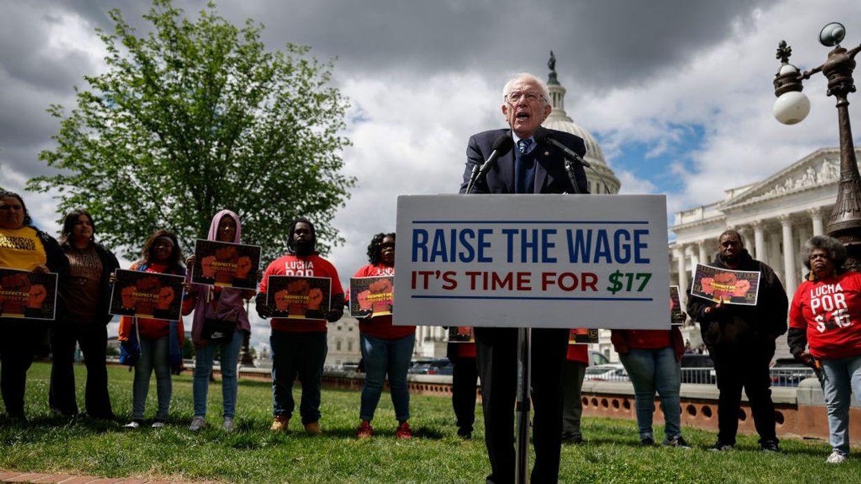 Sen. Bernie Sanders stands behind a podium that reads, "Raise the Wage: It's Time for $17."