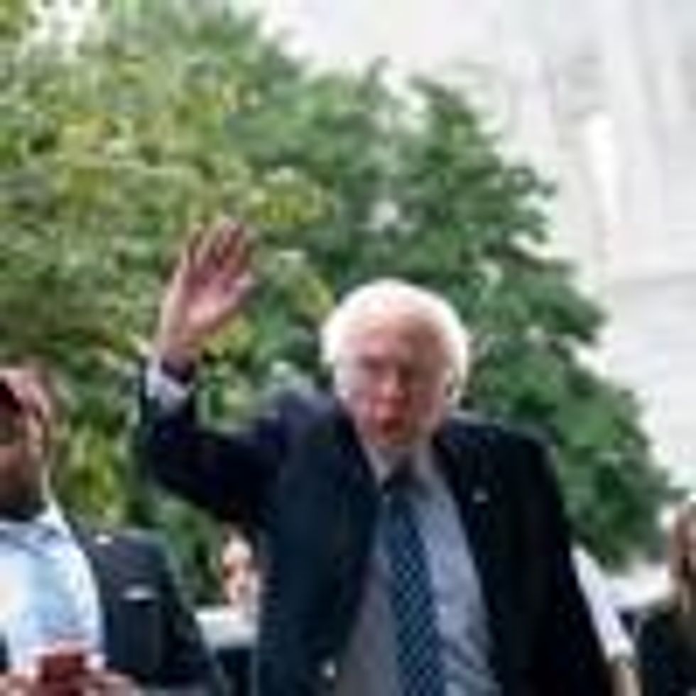 Sen. Bernie Sanders waves at demonstrators on Capitol Hill