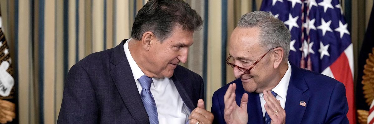 Sen. Joe Manchin and Senate Majority Leader Chuck Schumer clap during a White House event