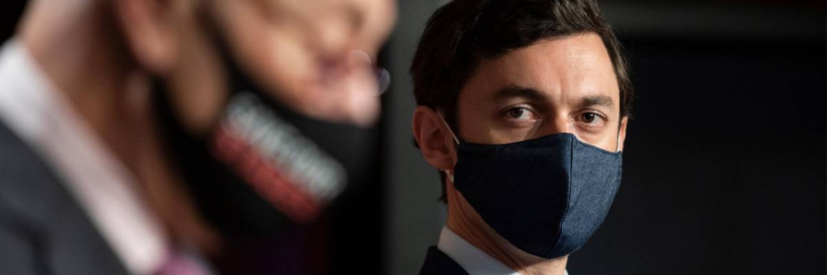 Sen. Jon Ossoff listens to Senate Majority Leader Chuck Schumer