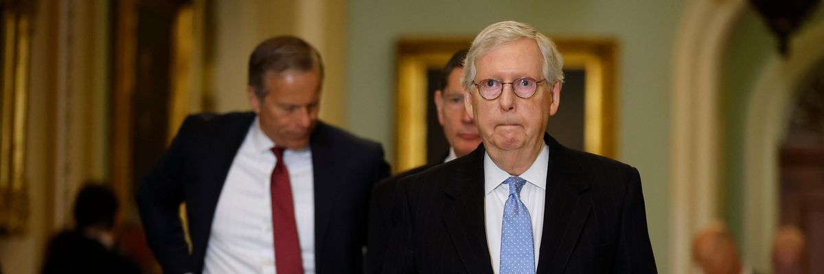 Senate Minority Leader Mitch McConnell walks with fellow senators