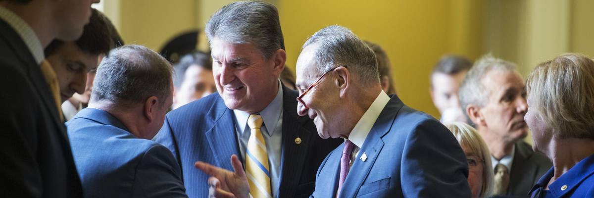 Sens. Chuck Schumer (D-N.Y.) and Joe Manchin (D-W.Va.) talk with colleagues at the U.S. Capitol on November 16, 2016.