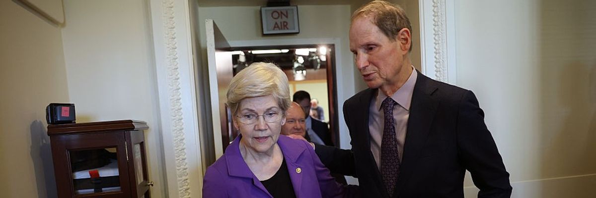 Sens. Elizabeth Warren walks with Sen. Ron Wyden
