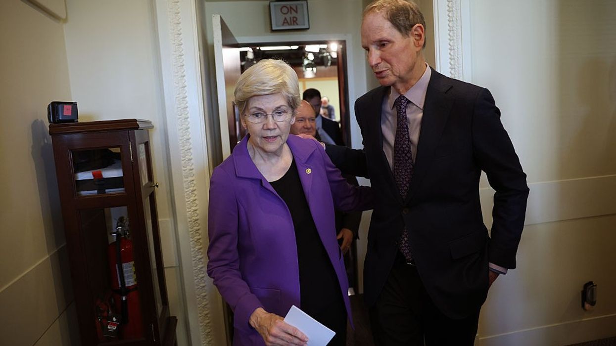 Sens. Elizabeth Warren walks with Sen. Ron Wyden