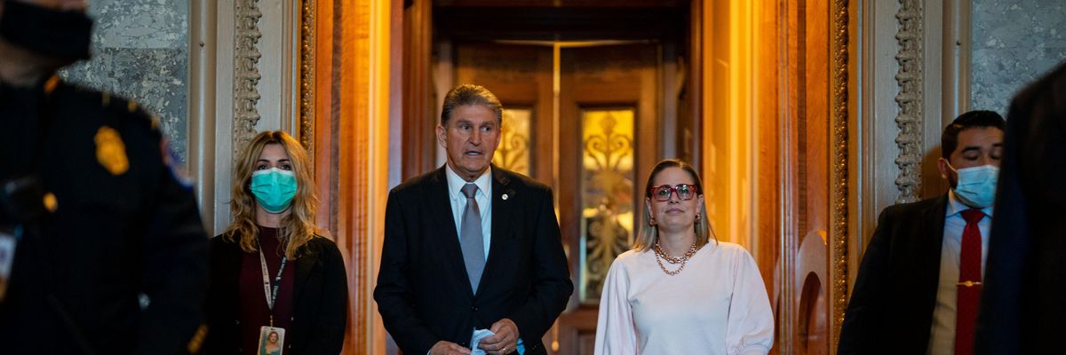 Sens. Joe Manchin and Kyrsten Sinema walk after a vote