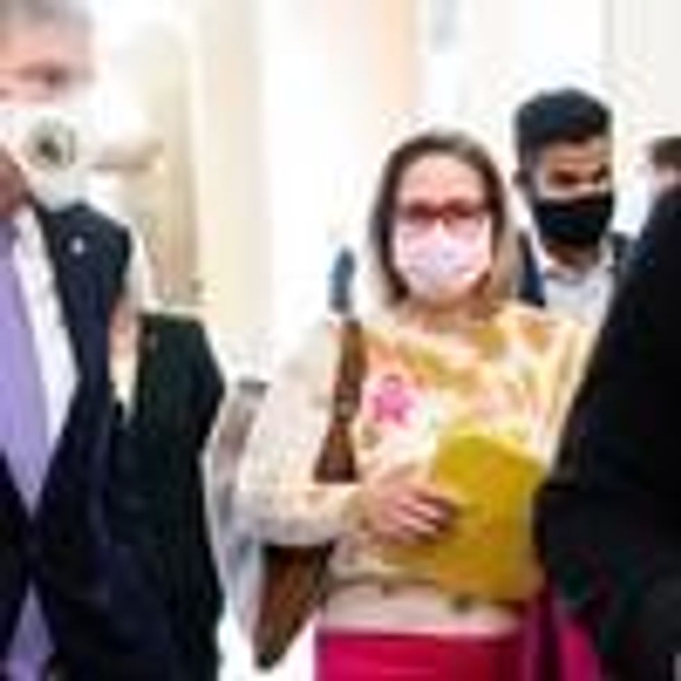 Sens. Joe Manchin and Kyrsten Sinema walk in the U.S. Capitol building.