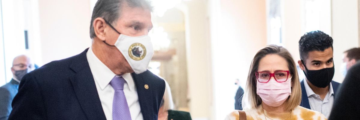 Sens. Joe Manchin and Kyrsten Sinema walk in the U.S. Capitol building.