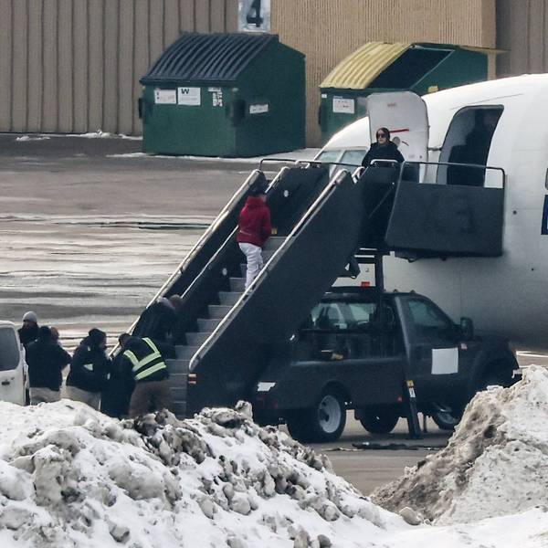 Shackled people board a deportation flight