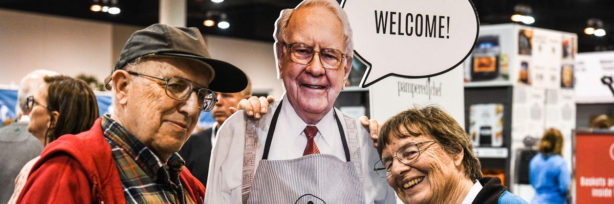 Shareholders stand with a cut out of billionaire Warren Buffet.