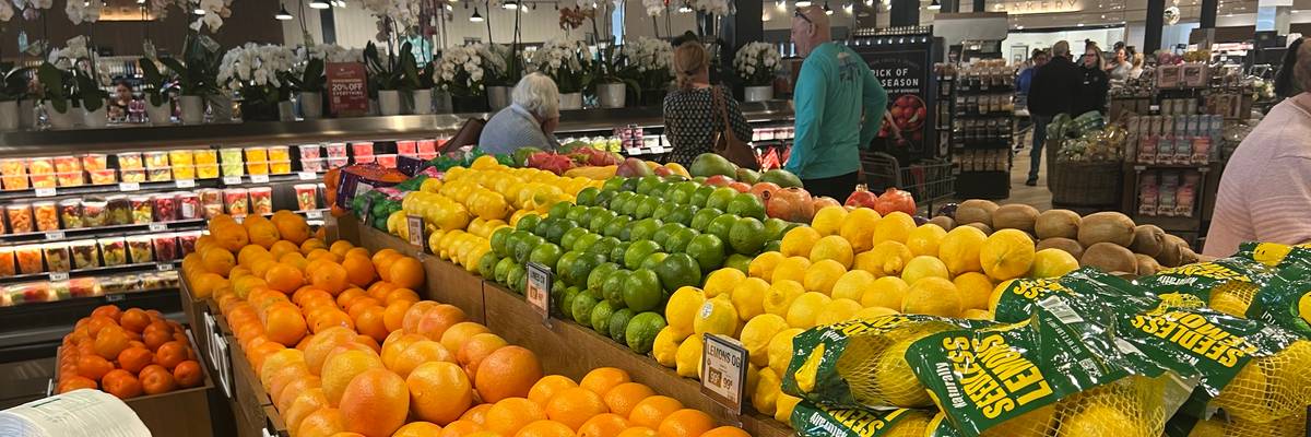 Shoppers browse the produce section of a Fresh Market grocery store