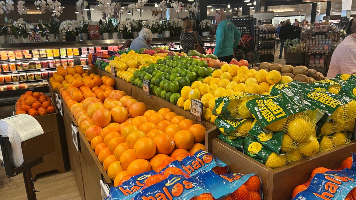 Shoppers browse the produce section of a Fresh Market grocery store