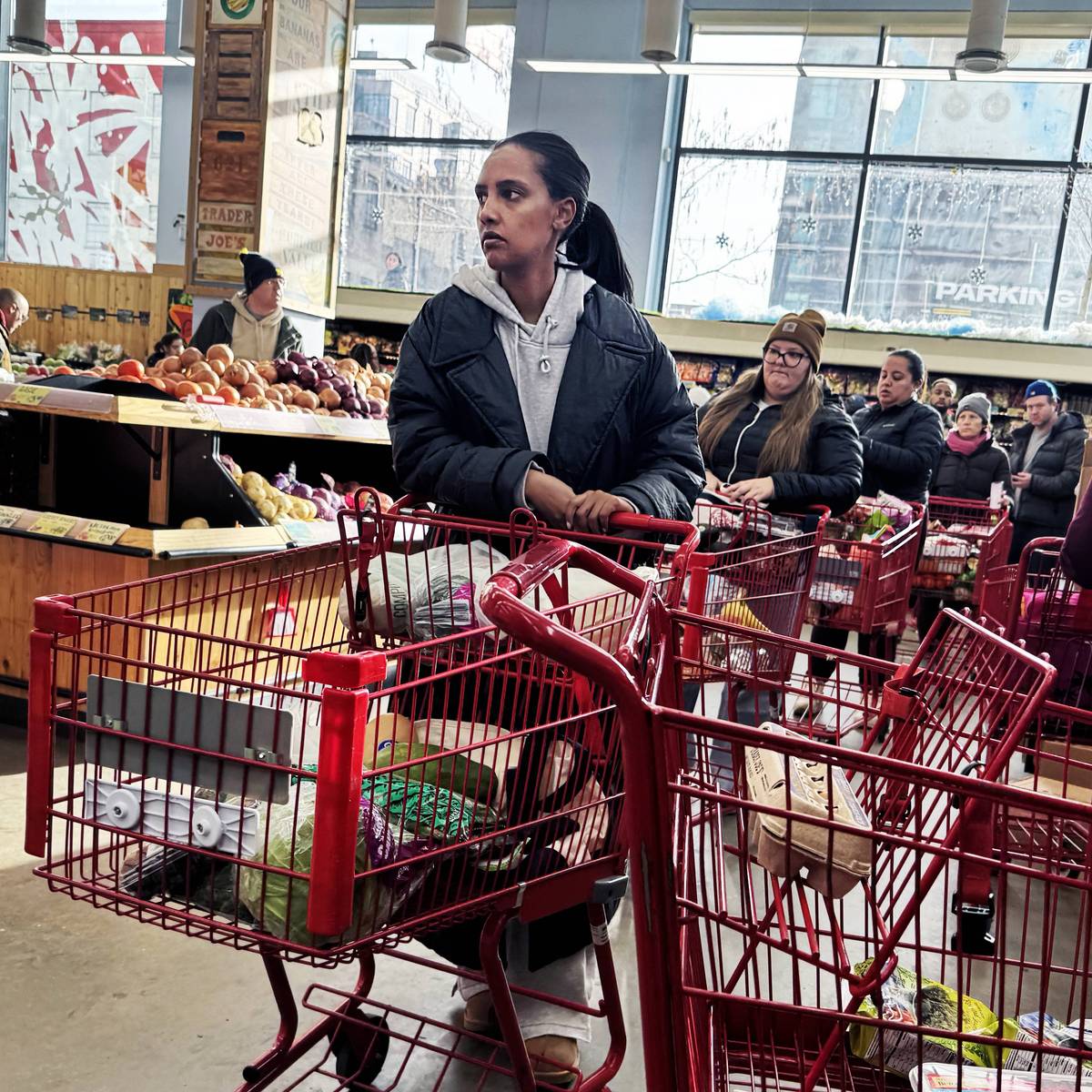 Shoppers wait in line at a grocery store in Washington, DC on January 23, 2026. 