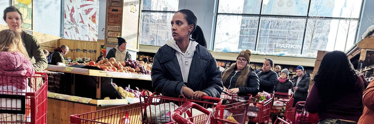 Shoppers wait in line in a grocery store.