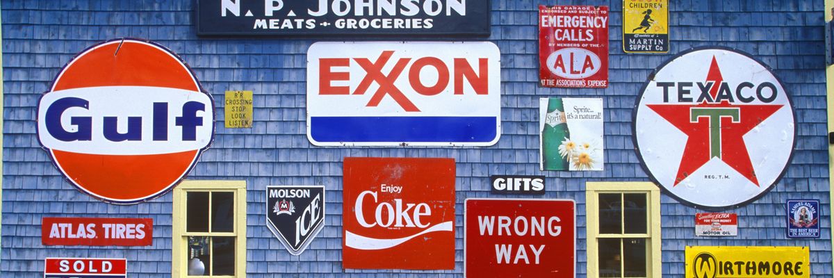 Sign on the side of a gas and service station. One of them says "Exxon."