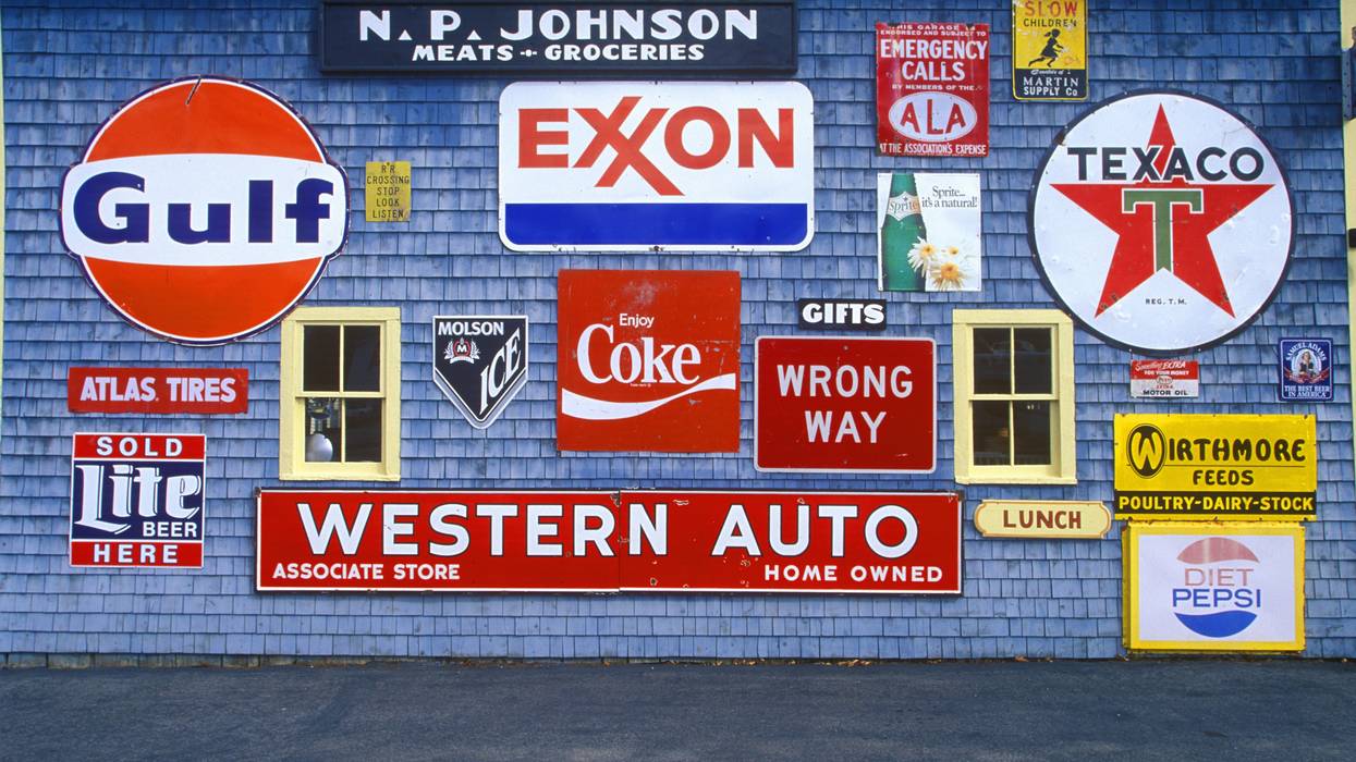 Sign on the side of a gas and service station. One of them says "Exxon."