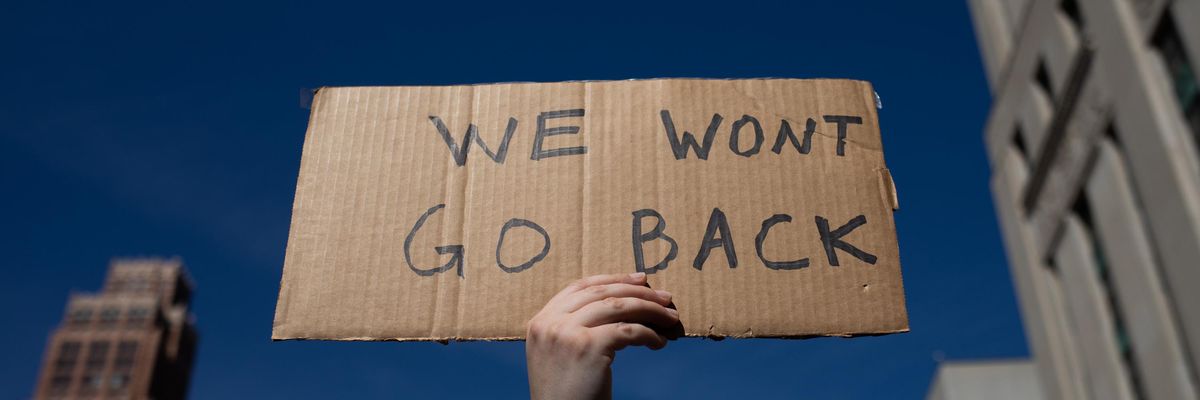 Sign reads "We Won't Go Back," a reference to abortion rights.