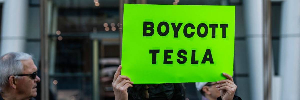 Sign says "Boycott Tesla"