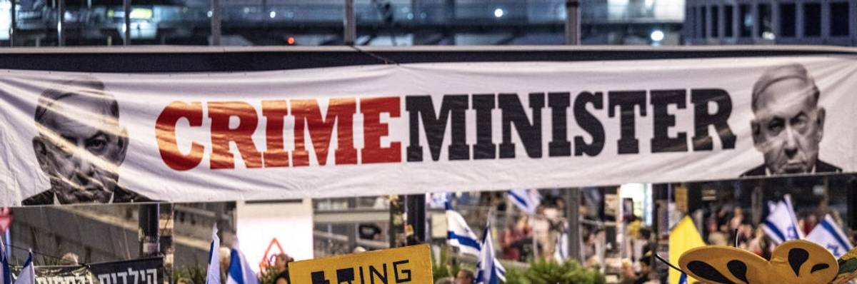 Sign says "Crime Minister" with picture of Prime Minister Netanyahu