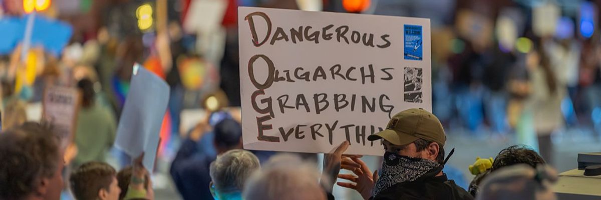 Sign says, Dangerous Oligarchs Grabbing Everything