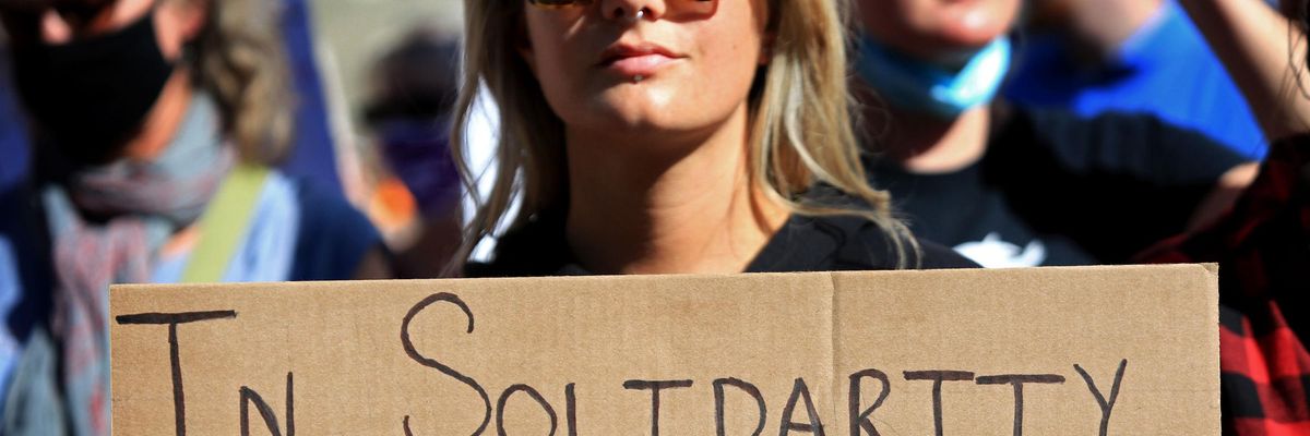 Sign says in solidarity with Texan bodies