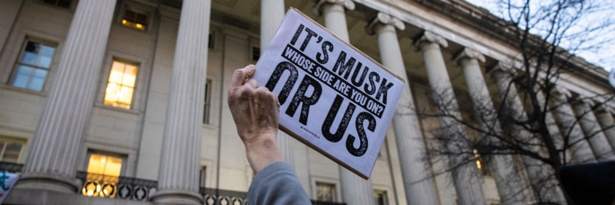 Sign says: "It's Musk or US... Whose Side Are You On"