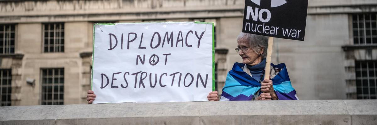 Signs read "Diplomacy Not Destruction" and "No Nuclear War"