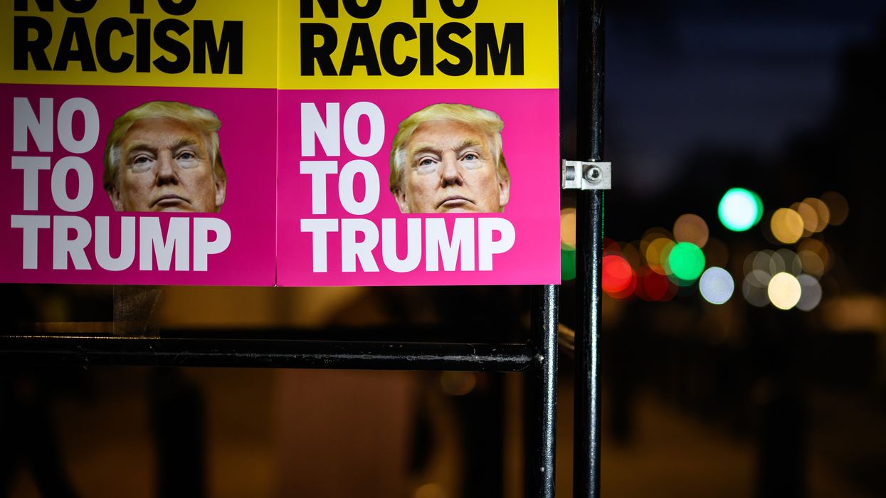 Signs read "No to Racism No to Trump."