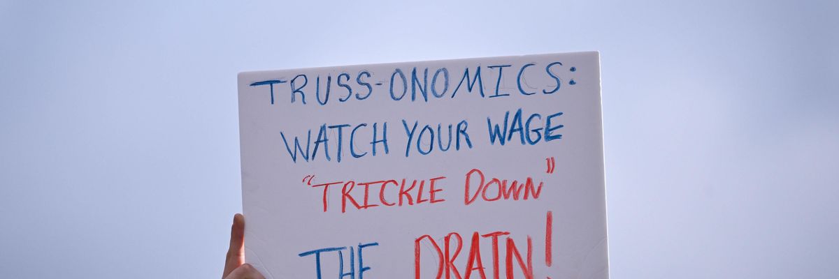Signs reads "Truss-onomics: Watch your wage 'trickle down' the drain!"
