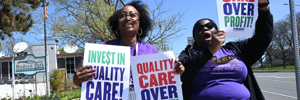 Signs say: "Quality Care Over Profits"