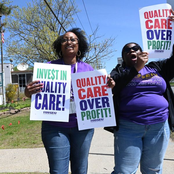 Signs say: "Quality Care Over Profits"