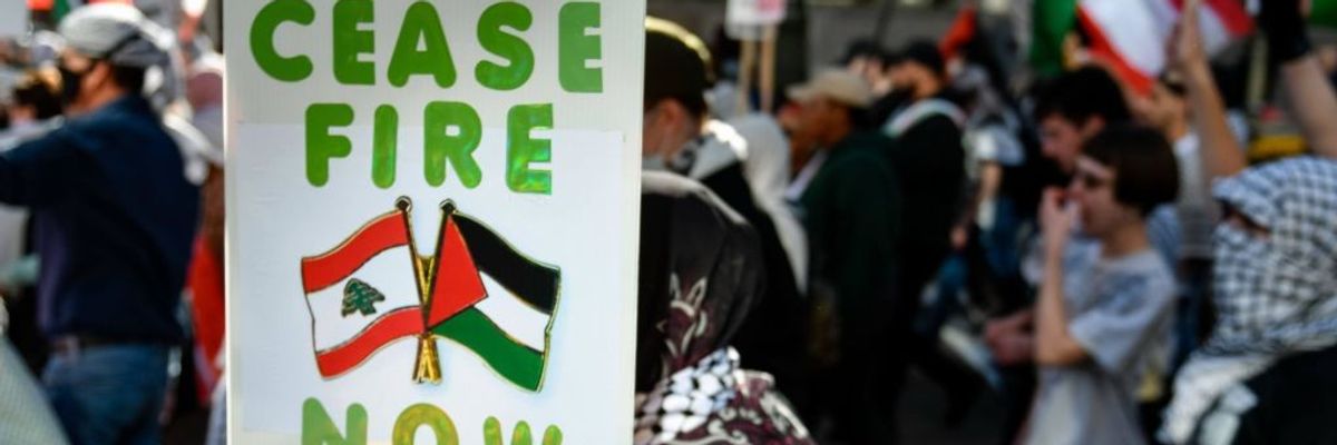 Signs says "Cease-Fire Now"