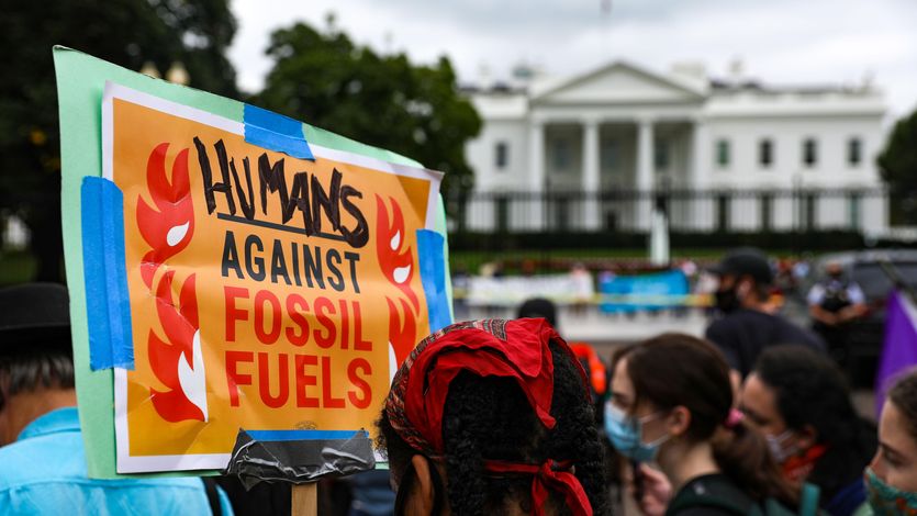 Signs says "Humans agsinst fossil fuels"