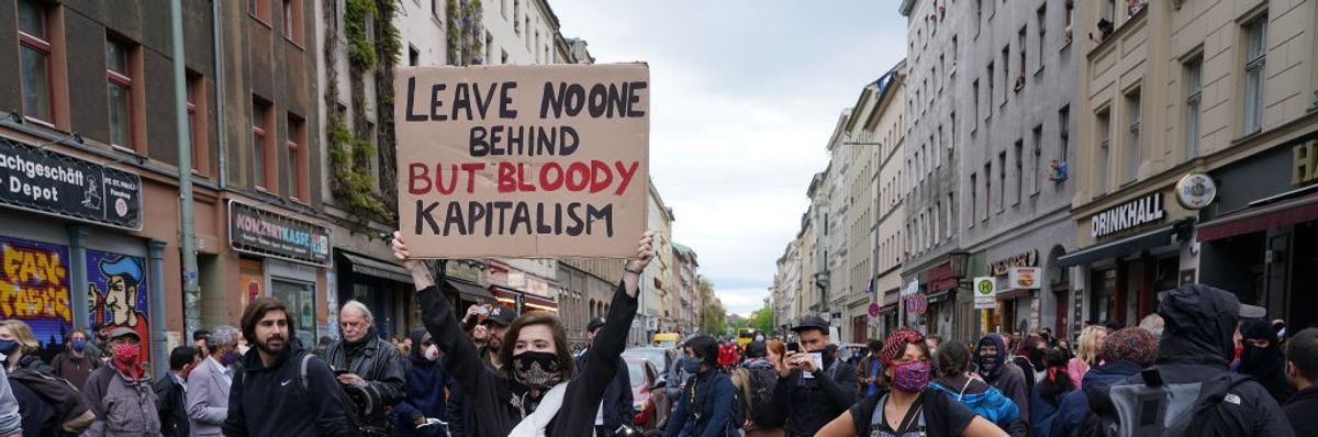 Signs says "Leave noone behind but bloody kapitalism"