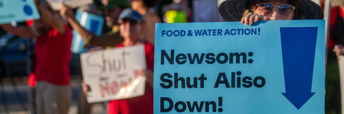 Signs says "Newsom: Shut Aliso Down"