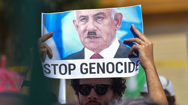 Signs says "Stop Genocide"