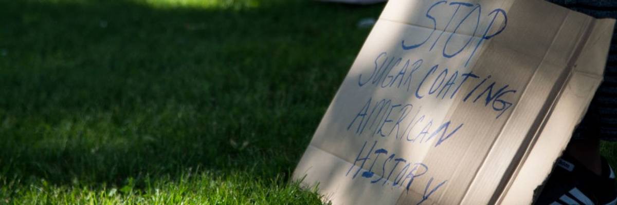 Signs says "Stop sugarcoating American history"