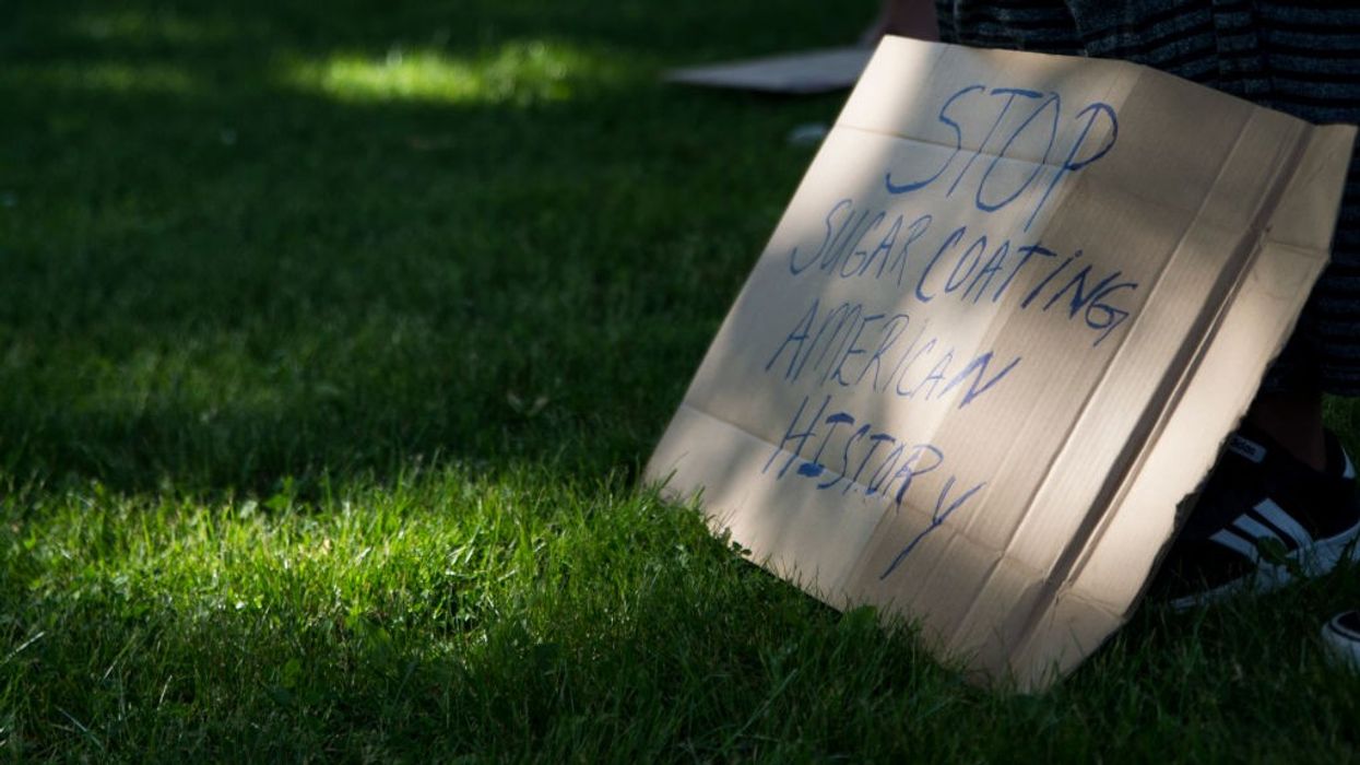 Signs says "Stop sugarcoating American history"