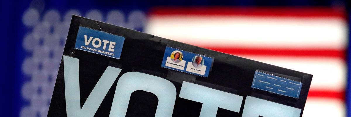 Signs says "Vote" in front of an American flag.