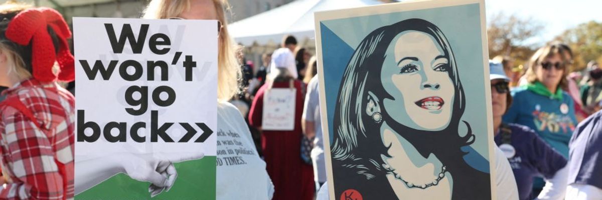 Signs says "We Won't Go Back" next to picture of Kamala Harris, which says "Forward"